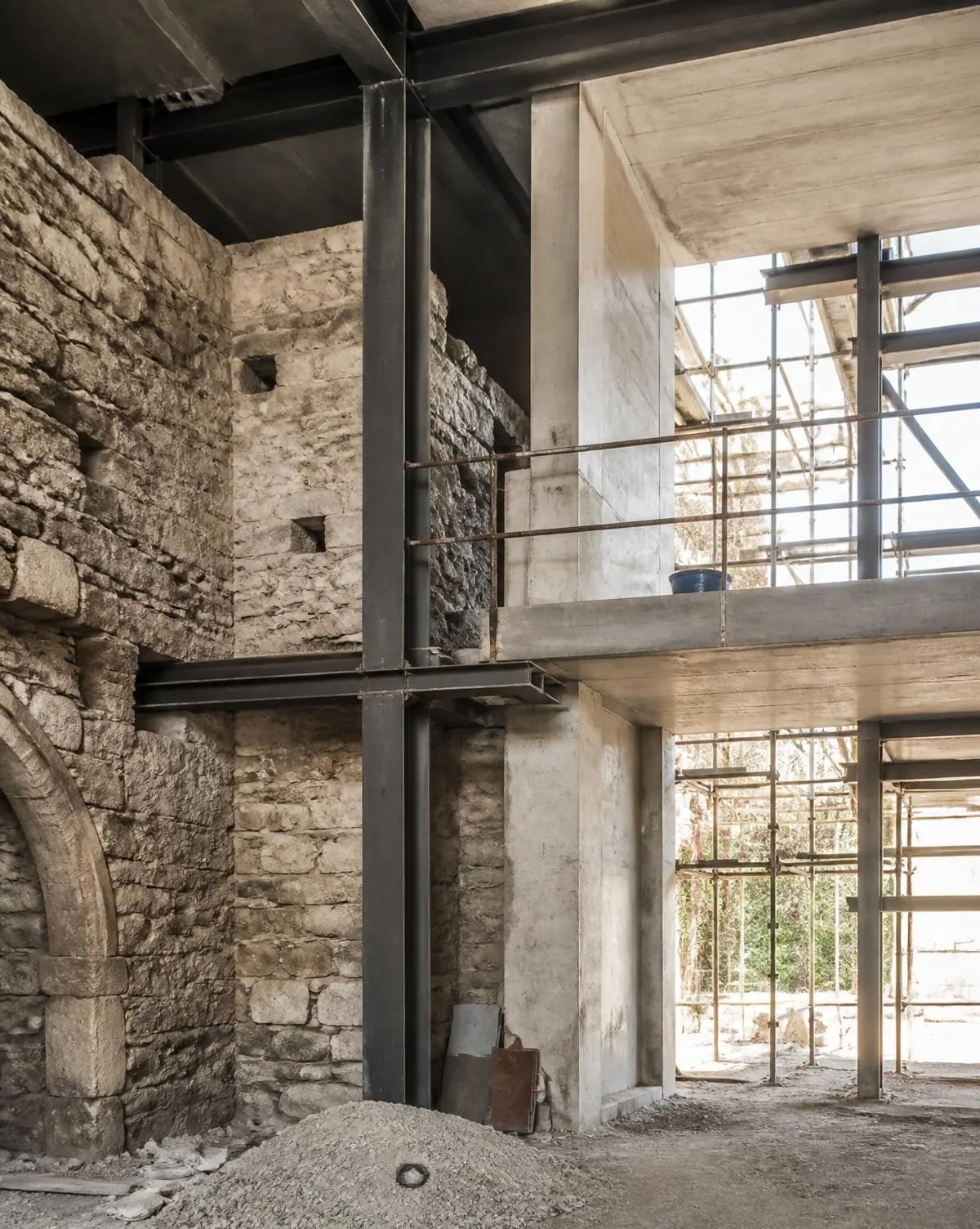 Rehabilitación de edificio con muro de piedra existente y estructura metálica nueva